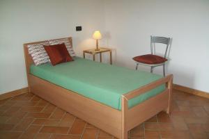 een slaapkamer met een bed met een stoel en een lamp bij La Casa Del Borgo in Beverino