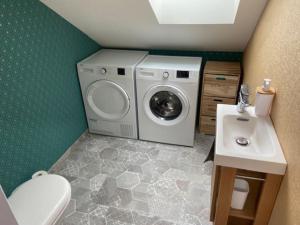een wasmachine in een badkamer met een wastafel bij La Maison Passageon, Tout confort in Châteauroux