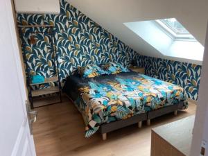 a bedroom with a bed with a blue patterned wall at La Maison Passageon, Tout confort in Châteauroux