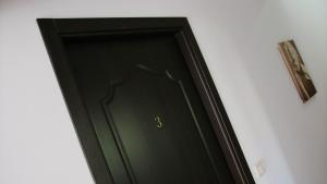 Una porta nera con il numero tre sopra. di Casa Guşă a Borsa