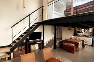 uma sala de estar com uma escada e uma sala de jantar em Loft familial avec grand jardin verdoyant em Paris