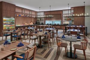 a rendering of a restaurant with tables and chairs at Four Points by Sheraton Desaru in Desaru