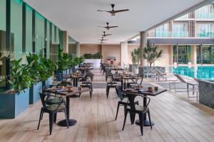 デサルにあるFour Points by Sheraton Desaruのテーブルと椅子のあるレストラン、プールを提供しています。