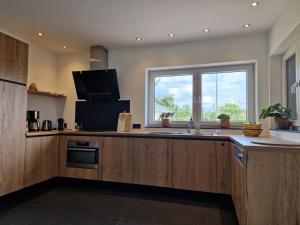 a large kitchen with a sink and a window at Huize Clementina in Peer