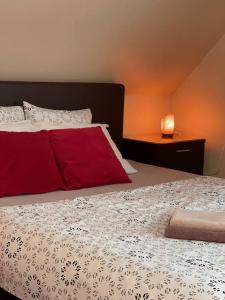 a bedroom with a bed with red and white sheets at Zeltini in Riga