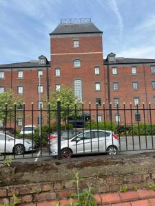 due auto parcheggiate di fronte a un edificio di mattoni di Priestley Court a Warrington