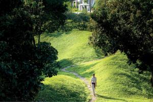 a woman walking down a dirt path in a field at Phulay Bay, A Ritz-Carlton Reserve in Tab Kaek Beach