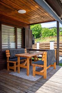 eine Holzterrasse mit einem Holztisch und 2 Stühlen in der Unterkunft Ferienhaus mit Göttweigblick in Furth