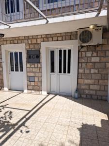 two doors on a brick building with a patio at Apartments Dragišić in Sveti Stefan