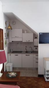 a kitchen with white cabinets and a sink and a table at Casa Lenzi in Portoferraio