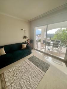 a living room with a green couch and a balcony at Altos De La Quinta II Apartment Marbella in Marbella