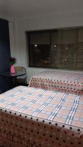 2 Betten in einem Zimmer mit Fenster in der Unterkunft Donde Gabriel in Chillán