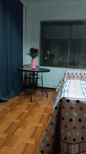 a room with two beds and a table with a vase of flowers at Donde Gabriel in Chillán