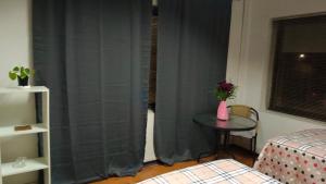 um quarto com uma mesa e uma janela com cortinas em Donde Gabriel em Chillán