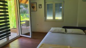 Zimmer mit einem Bett und einer Glasschiebetür in der Unterkunft Apartman MatiNik1 in Gornja Toplica