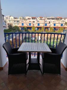 einen Tisch und Stühle auf einem Balkon mit Aussicht in der Unterkunft Appartamento incantevole a Misano Adriatico in Misano Adriatico