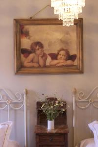 une peinture de trois anges accrochée à un mur dans l'établissement Casa Rural Melitón, à Povedilla