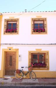 una bicicleta estacionada frente a un edificio blanco en Casa Rural Melitón, en Povedilla