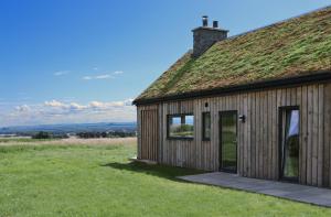 a wooden building with a grass roof at Eco-lodge with hottub + 2 wc in Elie