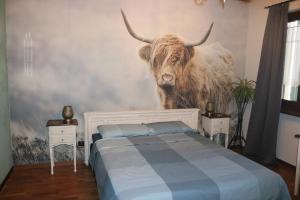 a bedroom with a mural of a cow on the wall at B&B Acquagrossa in San Martino Buon Albergo