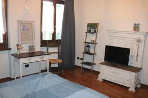ein Wohnzimmer mit einem TV und einem Kamin in der Unterkunft B&B Acquagrossa in San Martino Buon Albergo