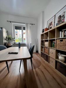 un soggiorno con tavolo, sedie e libreria di In-Experience City a Milano