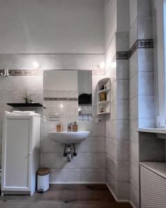 bagno con lavandino e parete piastrellata bianca di In-Experience City a Milano
