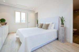 um quarto branco com uma cama branca e uma janela em Lustica Bay Apartment Maria By 2bhome em Radovići