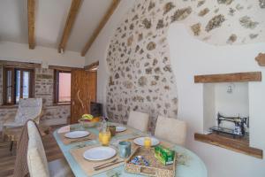 une salle à manger avec une table avec des assiettes et des bougies dans l'établissement Kidoni cottage, à Doukádes