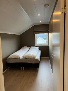 ein Schlafzimmer mit einem Bett in einem Zimmer mit einem Fenster in der Unterkunft Leilighet i rolige omgivelser i Lofoten 