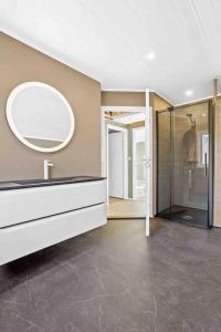a bathroom with a sink and a mirror and a shower at Leilighet i rolige omgivelser i Lofoten 