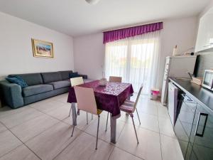 a kitchen and living room with a table and a couch at Vila Novak in Novalja