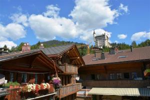 a group of buildings with flowers in front of them at Le Vieux Chalet in Gstaad