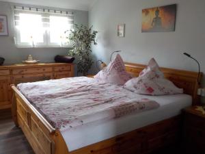 1 dormitorio con cama de madera y almohadas en Ferienwohnung Wolf, en Ensdorf