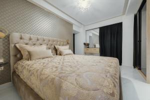 a bedroom with a large bed with a gold bedspread at Odysseus Luxury House in Rhodes Town