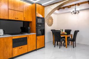 a kitchen with wooden cabinets and a table with chairs at Odysseus Luxury House in Rhodes Town