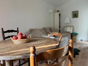 een tafel met een mand appels en een bank bij Charming village house in Goult in Goult