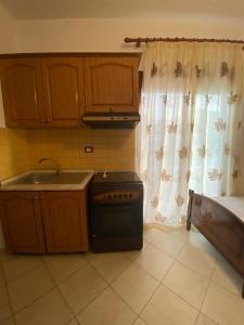 a kitchen with a stove and a sink and a window at VIOLCA GUEST HOUSE in Durrës