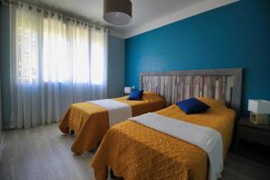 two beds in a room with blue walls at La Casa Del Pou classée 3 étoiles proche Céret et Thuir Terrain 800m2 Parking privé in Llauro