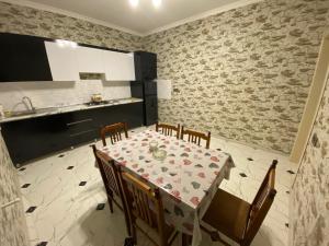 une salle à manger avec une table et des chaises ainsi qu'une cuisine dans l'établissement Dreamed Villa In Gabala, à Qabala