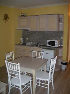 サニービーチにあるVictoria Residence PS Apartmentのキッチン(テーブル、椅子付)、キッチン(シンク付)
