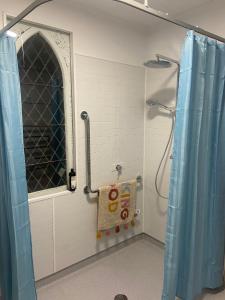 a bathroom with a shower with a window and a towel at The Church Millers Flat in Millers Flat