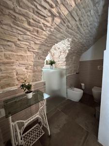 ein Badezimmer mit einer Steinmauer und einem WC in der Unterkunft MC 1640 in Quasani