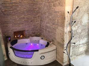 eine Whirlpool-Badewanne in einem Zimmer mit Kamin in der Unterkunft MC 1640 in Quasani