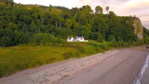 a house on a hill next to a dirt road at Craigneuk in Benderloch near Oban, stunning home with sea views in Oban