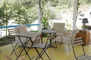 a porch with chairs and a table and a desk at The Sea Turtle Camp in Dhërmi