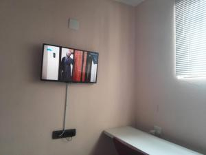 a flat screen tv hanging on a wall at The Stone Guest House in Teyateyaneng