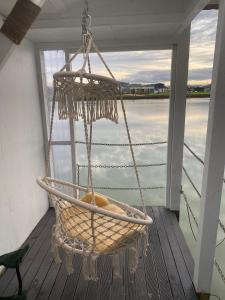 a hammock hanging from a porch on a boat at On the water boat House in Whangarei