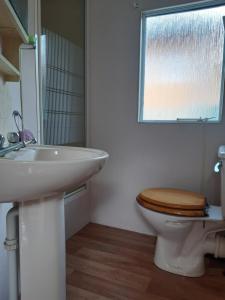 a bathroom with a toilet and a sink and a window at Maringotka - Mobilný dom , Hrabušice in Spišská Nová Ves