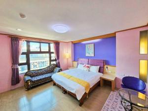 ein Schlafzimmer mit einem großen Bett und einem Fenster in der Unterkunft 恆春古城親子民宿 in Altstadt von Hengchun
